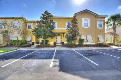 an empty parking lot in front of a yellow building at Serene Stay at Terra Verde Resort by Shine Villas 111 townhouse in Kissimmee