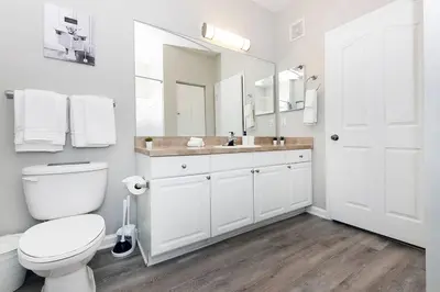 a white bathroom with a toilet and a sink at Orlando Retreat 2B2B / Disney-Universal-SeaWorld in Orlando