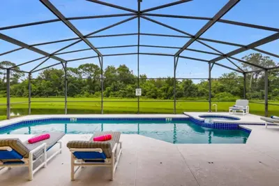 a swimming pool with two chairs and a tent at Lakefront 6BR Resort Pool Home Near Disney in Kissimmee