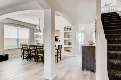 a dining room and living room with a table and chairs at Lakefront 6BR Resort Pool Home Near Disney in Kissimmee