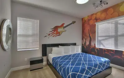 a bedroom with a bed with a painting on the wall at All Vacation Large Pool Home w-Cinema-Bowling Alley-Sleep 40 in Kissimmee