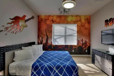 a bedroom with a bed with a guitar on the wall at All Vacation Large Pool Home w-Cinema-Bowling Alley-Sleep 40 in Kissimmee