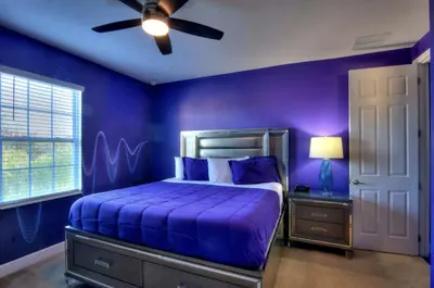 a purple bedroom with a bed and a ceiling fan at All Vacation Large Pool Home w-Cinema-Bowling Alley-Sleep 40 in Kissimmee