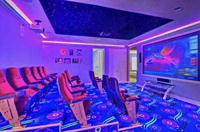 a movie room with red chairs and a large screen at All Vacation Large Pool Home w-Cinema-Bowling Alley-Sleep 40 in Kissimmee