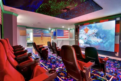 a room with red chairs and a large screen at Enchanting a Magical Orlando Trip in Kissimmee