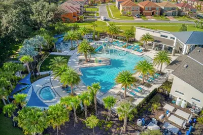 an aerial view of a resort pool with palm trees at Enchanting a Magical Orlando Trip in Kissimmee