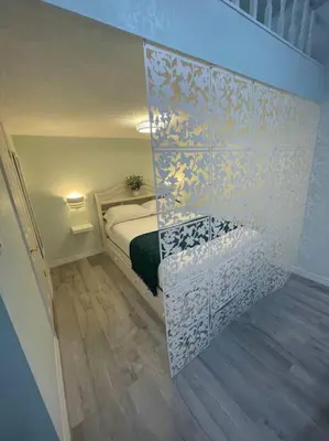 a small bedroom with a bed and a wall at The Tiny Cottage in the Springs/ Central FL in Altamonte Springs