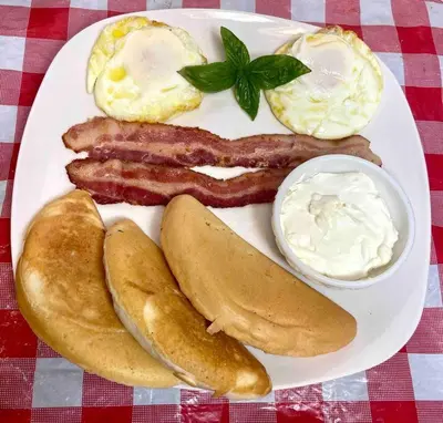 a plate of breakfast food with sausage eggs and bread at The Tiny Cottage in the Springs/ Central FL in Altamonte Springs