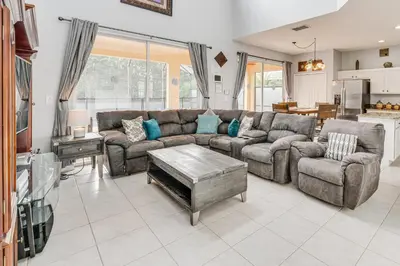 a living room with a couch and a table at 7 Mi to Disney Kissimmee Home with Pool and Hot Tub! in Kissimmee