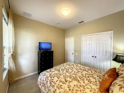 a bedroom with a bed and a flat screen tv at This amazing 6 Bedroom property with a lake view in Orlando