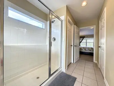 a walk in shower in a bathroom with a glass shower stall at This amazing 6 Bedroom property with a lake view in Orlando