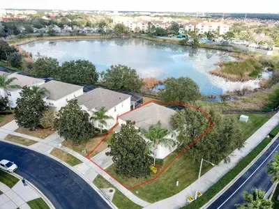 an aerial view of a house with a large lake at This amazing 6 Bedroom property with a lake view in Orlando