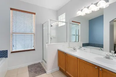 a bathroom with two sinks and a large mirror at Immaculate 4 bedrooms 3 bathroom in Windsor Palms in Kissimmee