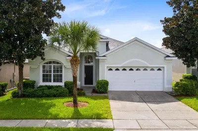 a palm tree in front of a house at Immaculate 4 bedrooms 3 bathroom in Windsor Palms in Kissimmee