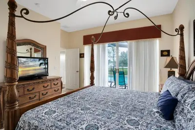 a bedroom with a bed and a flat screen tv at Tropical and peaceful, this 5 bed with Pool & Spa in Orlando