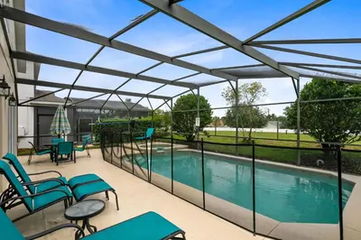 a patio with a swimming pool with blue chairs and tables at Tropical and peaceful, this 5 bed with Pool & Spa in Orlando