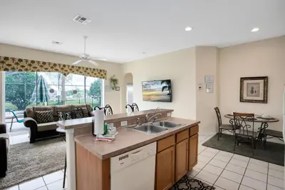 a kitchen with a sink and a living room at Tropical and peaceful, this 5 bed with Pool & Spa in Orlando