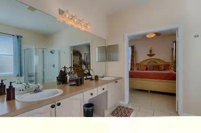 a bathroom with a sink and a bedroom with a bed at Resort 5 Bed Private Pool & Spa, Game Room Home in Kissimmee