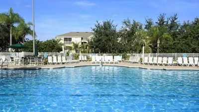 a swimming pool with white chairs and a pool at Resort 5 Bed Private Pool & Spa, Game Room Home in Kissimmee