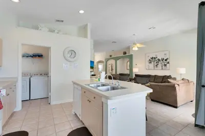 a kitchen with a sink and a living room at Four Bedroom/3 Bath South Facing Pool/Spa Villa in Kissimmee