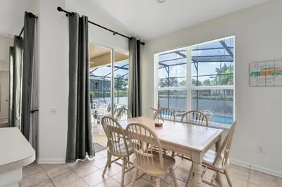 a dining room with a table and chairs at Four Bedroom/3 Bath South Facing Pool/Spa Villa in Kissimmee
