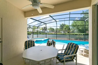 a dining room with a table and chairs and a pool at Four Bedroom/3 Bath South Facing Pool/Spa Villa in Kissimmee