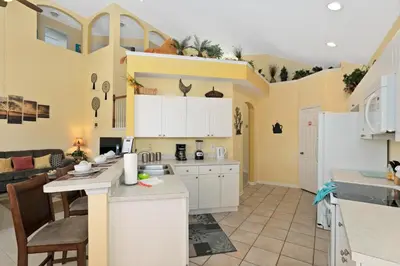 an open kitchen and living room with a couch at Fantastic Resort 5BR House - South Facing Pool/Spa in Kissimmee
