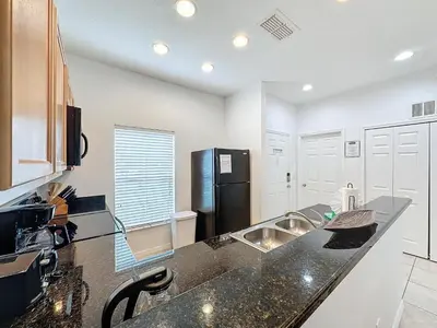 a kitchen with a sink and a black refrigerator at Amazing Townhouse close to Disney 2 Bed 2.5 Bath in Kissimmee