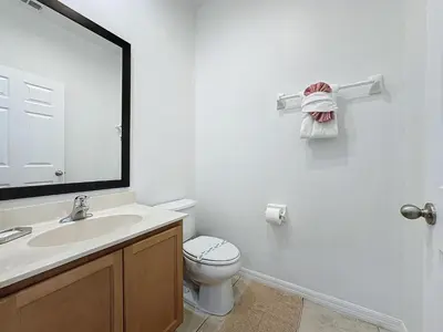 a bathroom with a toilet and a sink and a mirror at Amazing Townhouse close to Disney 2 Bed 2.5 Bath in Kissimmee