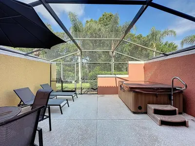 a large patio with a hot tub and benches at Amazing Townhouse close to Disney 2 Bed 2.5 Bath in Kissimmee