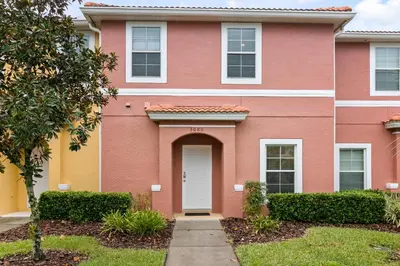 a pink house with a white door at Amazing Townhouse close to Disney 2 Bed 2.5 Bath in Kissimmee