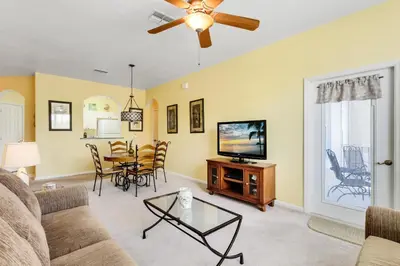 a living room with a couch and a tv and a table at Close to Disney Condo 3 Bed / 2 Bath in Kissimmee