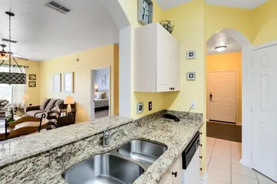 a kitchen with a sink and a living room at Close to Disney Condo 3 Bed / 2 Bath in Kissimmee