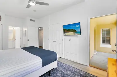 a bedroom with a bed and a tv on the wall at Disney Area 4 bed/ 3.5 Bathroom Emerald Island in Kissimmee