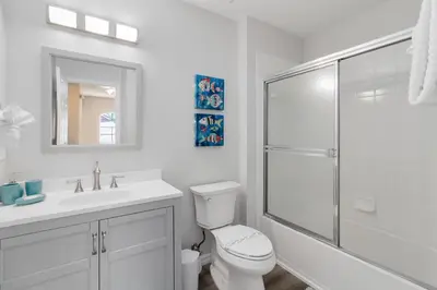 a white bathroom with a toilet and a shower at Disney Area 4 bed/ 3.5 Bathroom Emerald Island in Kissimmee