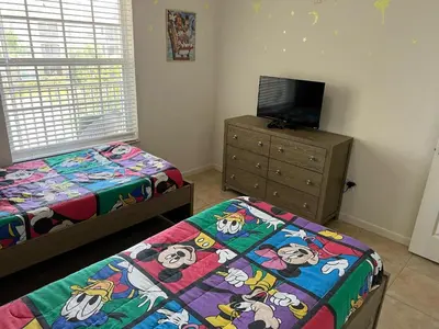 a bedroom with two beds and a flat screen tv at Amazing Resort 2 bed condo close to Disney in Kissimmee