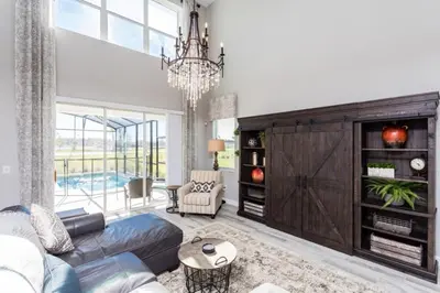 a living room with a blue couch and a chandelier at Five bedroom home is ideal for an elegant vacation in Kissimmee