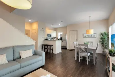a living room and kitchen with a couch and a table at Lucaya Village Resort - 4 Bed 3 Bath Townhouse in Kissimmee
