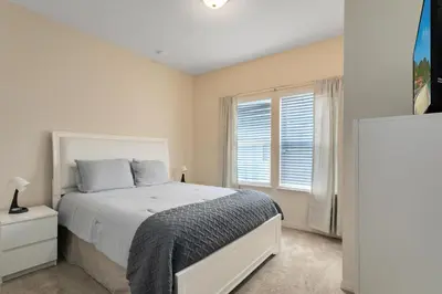 a white bedroom with a bed and a window at Lucaya Village Resort - 4 Bed 3 Bath Townhouse in Kissimmee