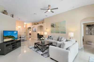 a living room with a couch and a tv at Amazing Disney Dream Getaway in Windsor Palms! in Kissimmee