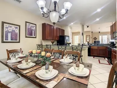 a kitchen and dining room with a table and chairs at Fantastic 7 Bed 6 Bath in Prestigious Gated Comm. in Orlando