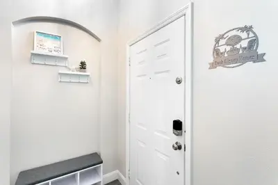 a hallway with a white door and a bench at Amazing 6 Bed Disney Dream Getaway in Windsor Palm in Kissimmee
