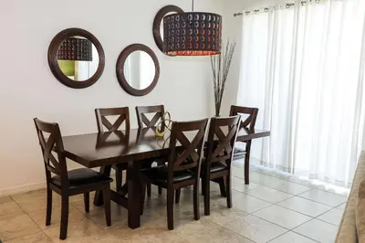 a dining room table with chairs and a mirror at Amazing 4 bedroom house near Disney in Kissimmee