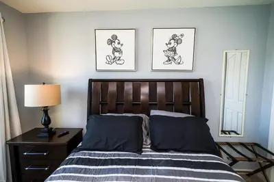 a bedroom with a bed with two pictures on the wall at Amazing 4 bedroom house near Disney in Kissimmee