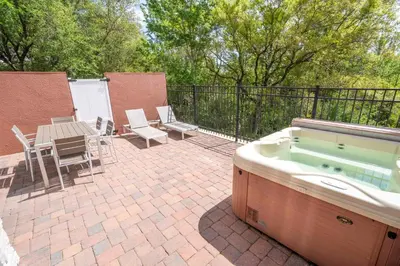 a hot tub on a patio with a table and chairs at 5 Min to Disney Dream 5 Suites Villa in Orlando
