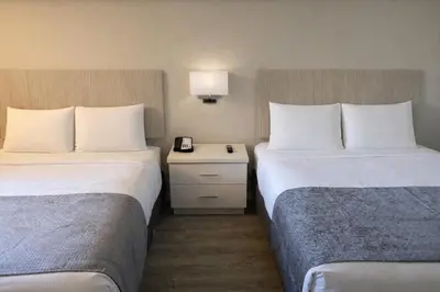 a hotel room with two beds and a table with a lamp at Orlando International Drive North Hotel in Orlando