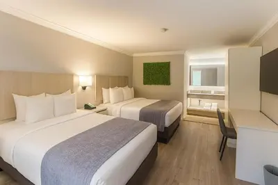 a hotel room with two beds and a television at Orlando International Drive North Hotel in Orlando