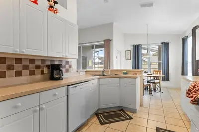a kitchen with white cabinets and a counter top at 3Br 2Ba Private Pool Villa just steps away from villa in Kissimmee