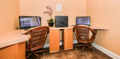 a desk with two computer monitors and two chairs at Zen Escape At Terra Verde By Shine Villas in Kissimmee