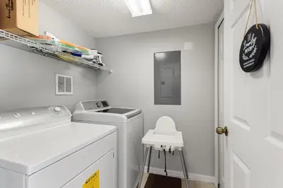 a laundry room with a washing machine and a stool at Zen Escape At Terra Verde By Shine Villas in Kissimmee
